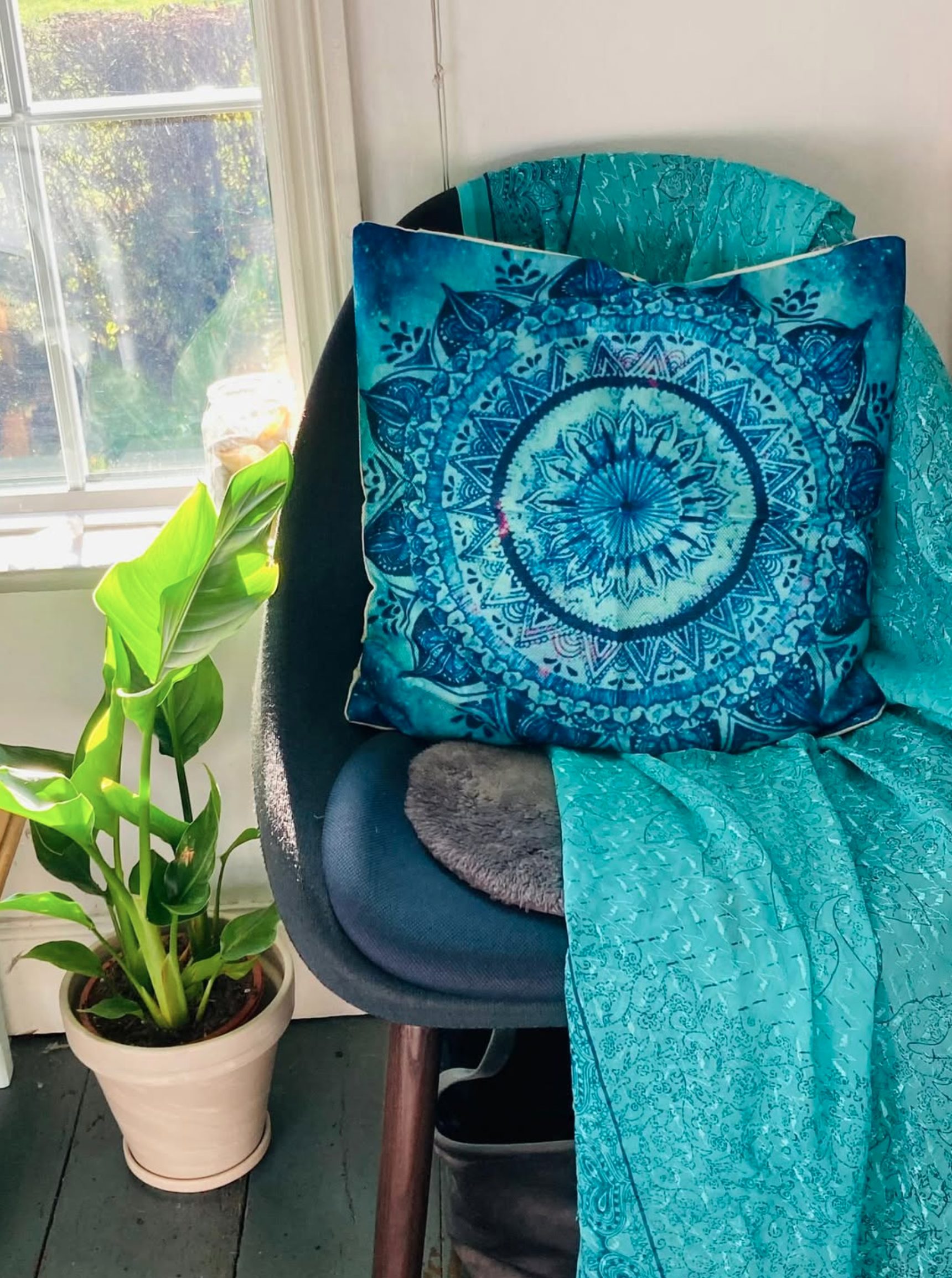 Teal chair, mandala cushion and plant in the Soul Peace Holistic Healing room