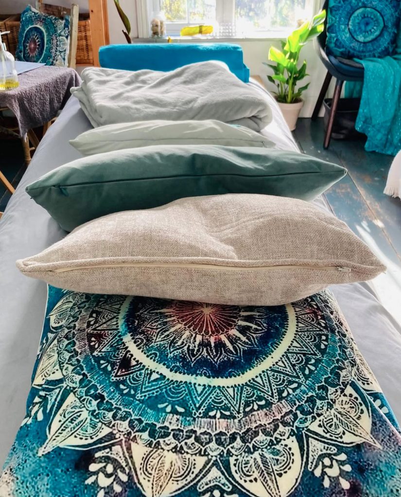 Prepared treatment bed with cushions in the Soul Peace Holistic Healing room