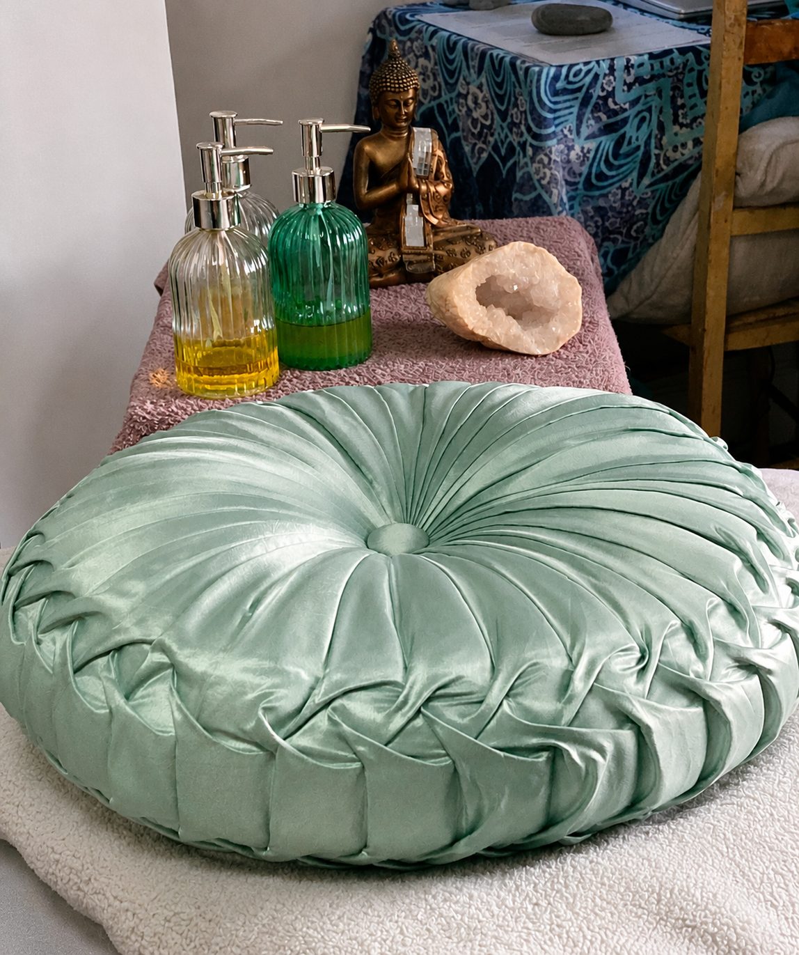 Reiki treatment space with a soft green cushion, oils and crystals